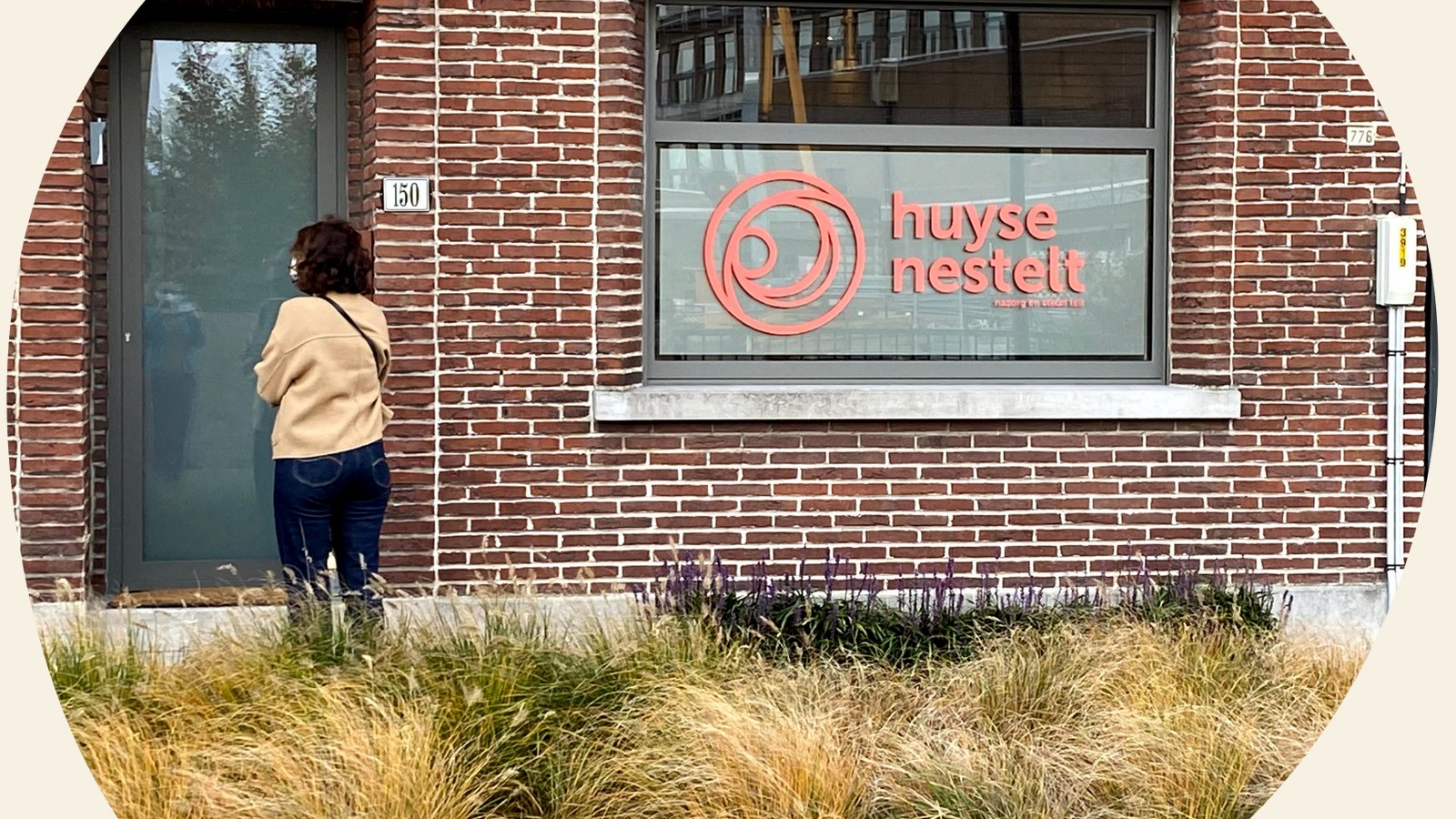 Het huis van Huyse Nestelt aan Roze 150 in Eeklo, met het logo op het raam.